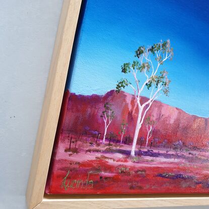 Australian landscape in blues and reds with white ghost gums in the foreground