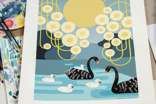 A family of Australian black swans swim gracefully on a moonlit river. The edges of the painting are filled with stylised circular Eucalyptus blossoms with swirling yellow stems. A pale golden moon hangs in the background. One of the cygnets rides on its mothers back while 3 other baby swans are in the water beside the parents.