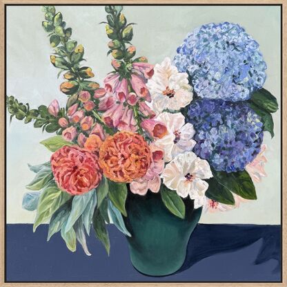 Painting of deep green vase filled with spring roses, foxgloves and hydrangeas, sitting on a dark navy cloth, framed in an oak float frame.