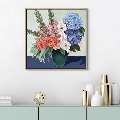 Painting of deep green vase filled with spring roses, foxgloves and hydrangeas, sitting on a dark navy cloth, framed in an oak float frame.