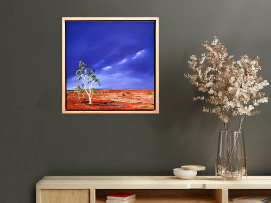 Australian landscape in yellows, oranges and deep blue sky with a road and gum trees, dust storm coming