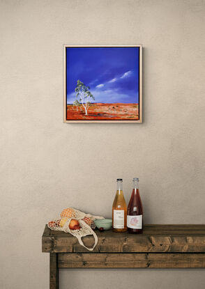 Australian landscape in yellows, oranges and deep blue sky with a road and gum trees, dust storm coming