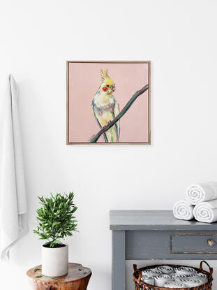 Yellow cockatiel portrait seated on a thin branch, with a retro peach background. Framed and ready to hang.