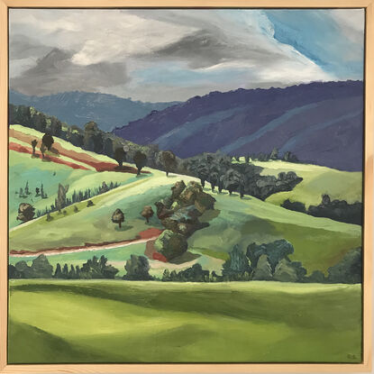 Rolling green hills of New England. Blue hazed hills in the background with trees scattered along the hills.  A track cut through the mountain for the cattle to graze up the steep incline.