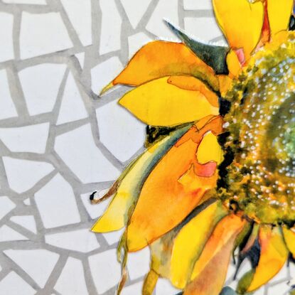 A single sunflower, facing towards the viewer, is created using watercolour. It sits in a blue and white detailed vase, on a blue and white tablecloth - both created using collaged paper. The background is a white, geometric, marble-like texture, also created in collaged paper. 