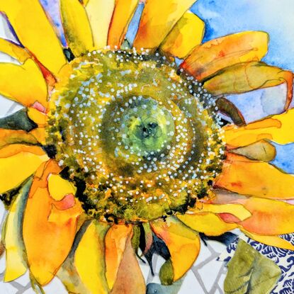 A single sunflower, facing towards the viewer, is created using watercolour. It sits in a blue and white detailed vase, on a blue and white tablecloth - both created using collaged paper. The background is a white, geometric, marble-like texture, also created in collaged paper. 