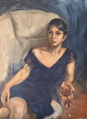 A young beautiful female holding a glass of wine leaning to the right of the frame staring to the right. 