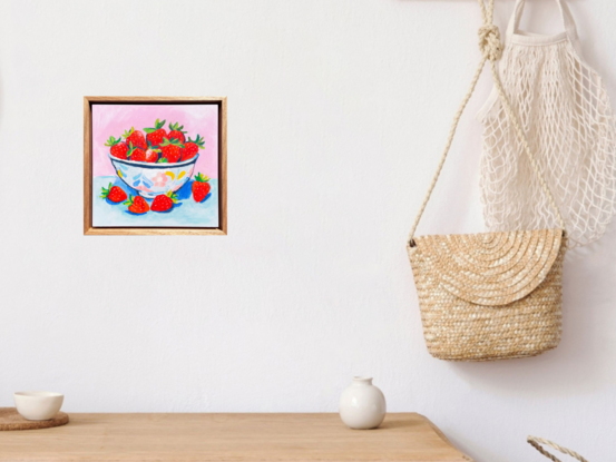 a textural bowl of strawberries with a pastel pink and blue background. 