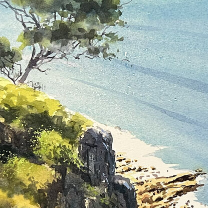 An elevated view over the ocean with rocks and vegetation.