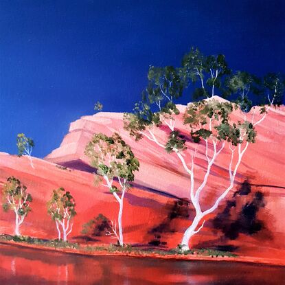 Australian landscape in oranges and deep blue sky with  gum trees and water reflections