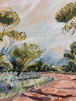 Spring grasses edge a red dirt track that weaves through mallee trees. A pink and blue sky have white whispering clouds. 