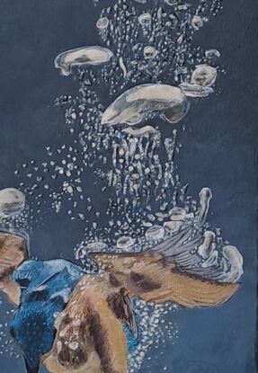 A blue and ochre kingfisher diving underwater and capturing a fish while bubbles float to the surface (some of them in relief)