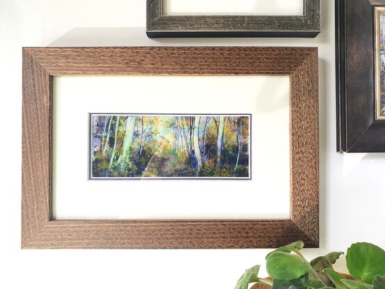 Framed miniature oil painting in purple and olive greens with mustard, of a sunlit sapling forest with dense understory scrub. By Victoria Collins. Frame is solid wood, dark toned. 