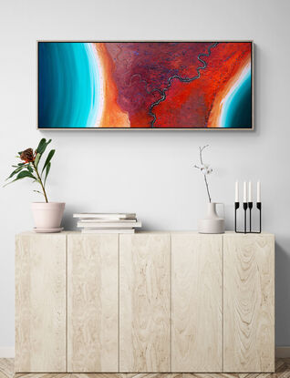 Framed modern abstract seascape print in colourful tones of red, orange and teal.