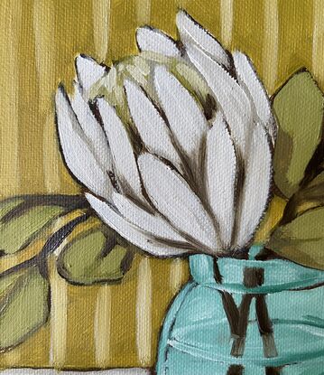 White protea in a glass vase with a striped background