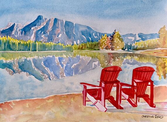 Deckchairs beside a lake side mountain view.