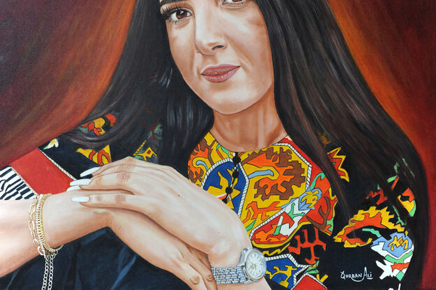 A graceful female portrait showcases a woman in a moment of quiet reflection. She is dressed in a Pakistani traditional outfit, radiating cultural richness. Her left hand cradles a wristwatch, while her right wrist adorns a delicate chain. The position of her hands conveys a sense of serenity and introspection.