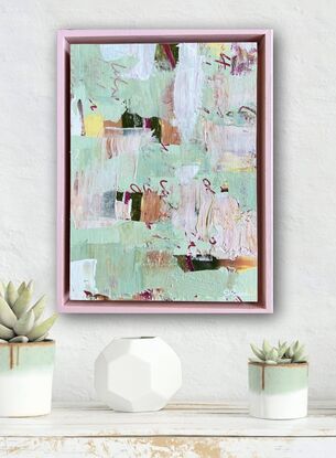 Pale green and pink, layered with text and texture, in a pink timber frame