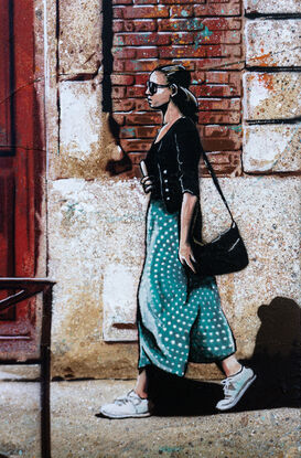 a woman walks past a set of old red doors in France