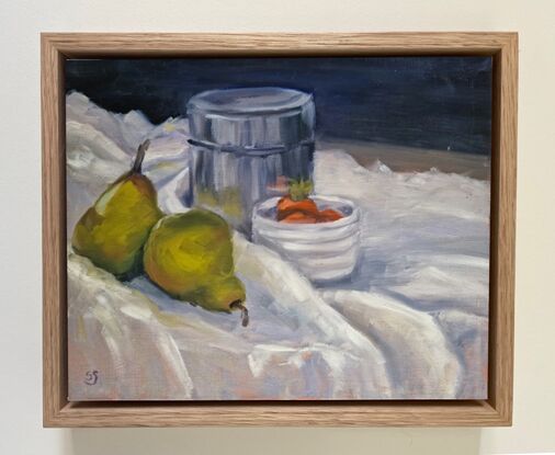 Two ripe green pears and some strawberries in a white bowl, with their reflections in a metal tin. On a white tablecloth.