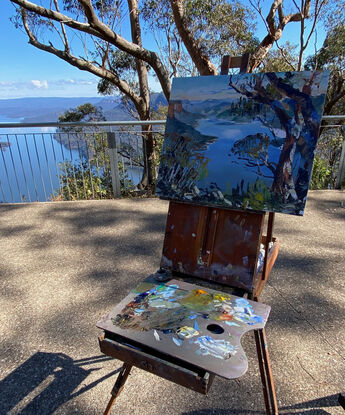 View of a blue dam with brown trees in front