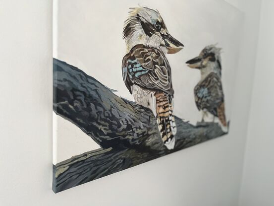 Two kookaburras perched gracefully on a sturdy tree branch, their vibrant feathers standing out against the muted backdrop of the grey sky. Their beauty adds a touch of vibrancy to the scene, capturing the eye with their vivid colors and lively presence.