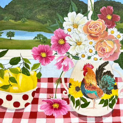 still life scene featuring a vase with a rooster filled with pink and white cosmos and orange roses next to a bowl with red spots filled with lemons, against a hinterland inspired landscape window view backdrop and a red gingham table cloth