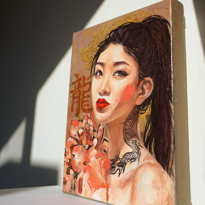 Asian girl with pink paint streak on cheek and dragon tattoo behind red flower