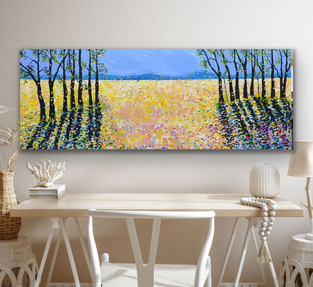 Bold striking brown black trees in two groups on the sides of the painting contrast with the sunny yellow fields   The striking  tree shadows create drama and interest against the medley of sunshine whilst  splashes of electric colour warm the scene. This is a striking piece to add vibrancy and interest to a room. There is an underlying feeling of positivity and happiness with the bright colour. 