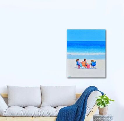 A colourful beach scene with three young women sitting in beach chairs chatting in front of the ocean.