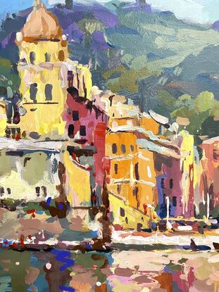 Colourful home on hill in a bay in Italy. Boats in the water. 