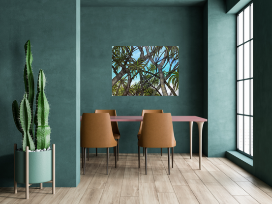 Pandanus palm trees silhouette against blue sky and the beach.
