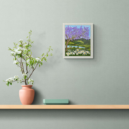 Jacaranda tree above a field of white daisies set against a a hinterland inspired backdrop with rolling green hills and blue sky