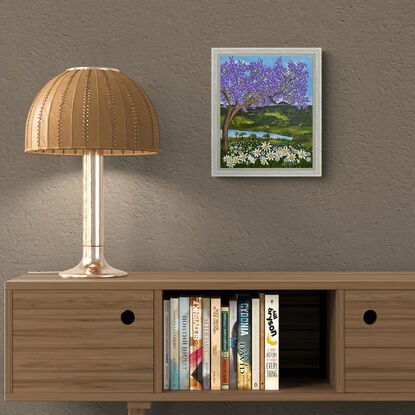 Jacaranda tree above a field of white daisies set against a a hinterland inspired backdrop with rolling green hills and blue sky