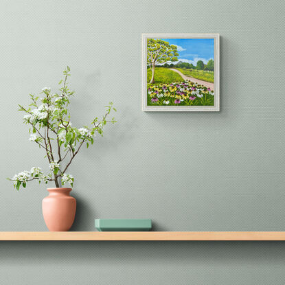 field of wild cosmos against a hinterland landscape scene featuring a path, a eucalyptus tree and a view of the glass house mountains 