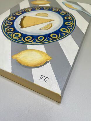 Slice of citrus tart on a blue and yellow plate on striped grey and white tablecloth 