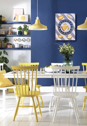 Slice of citrus tart on a blue and yellow plate on striped grey and white tablecloth 