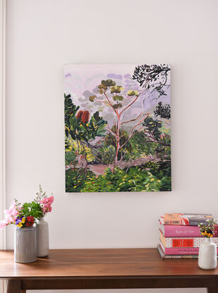 A lilac cloudy sky sits above spraggled eucalyptus and Australian native plants in a misty morning scene. 