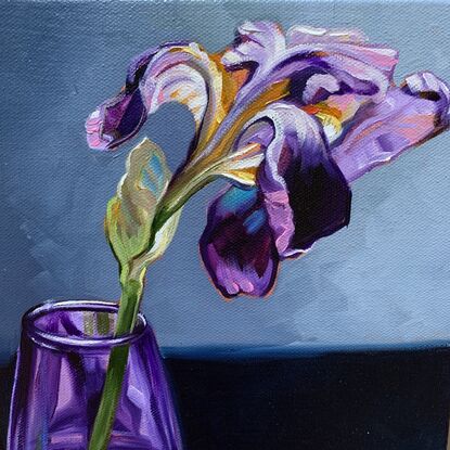 A single purple iris in a handblown purple glass vase