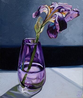 A single purple iris in a handblown purple glass vase