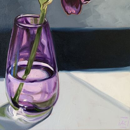 A single purple iris in a handblown purple glass vase