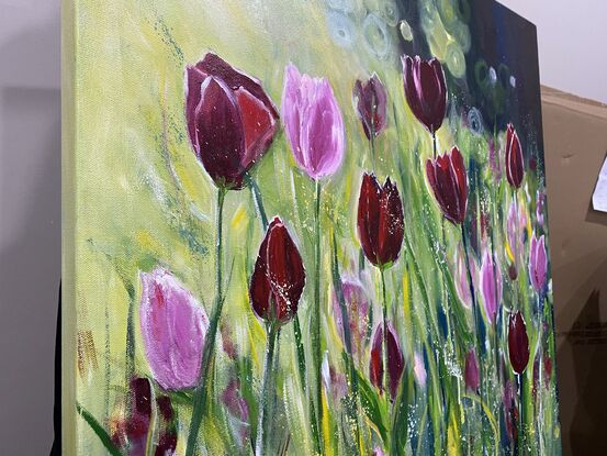 Glowing dark red tulips and bright pink tulips dancing in a breeze with the sun shining behind them and gently caressing the petals and stalks. This is a happy calming painting that warms your heart and will bring nature and positivity into your home. Captured moments of beauty untouched and glowing with light. 

This is an artwork with impact and statement and would be enhanced with a natural wood frame to add interest and beauty to your home however it is finished around the sides and ready to hang without the expense of a frame. 