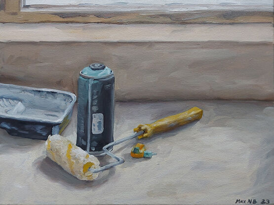 Still life of spray paint can, paint tray, paint roller and spray paint nozzle on table.