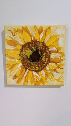 There are 7 small square paintings. There are a variety of subjects, one portrait of a man, two of a young woman (wrapped in a blanket & at the beach), water, a mug in a rainy window, a sunflower and hands slicing up an orange. 