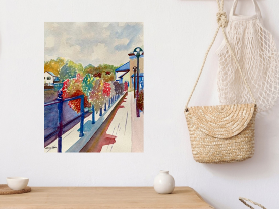 An artwork showing a display of flower baskets adorning the railings between a canal and a public house.