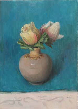 white flower buds in a small vase in a blue background