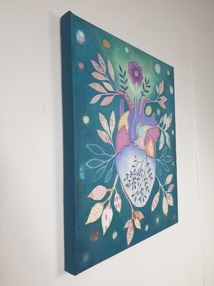 Original artwork by artist Libby Mills. A mixed media painting of a human heart. Vibrant in colour with teals, purples, pinks, orange and more.  Floral patterns with leaves coming out of the heart in a patchwork/ illustrative manner.