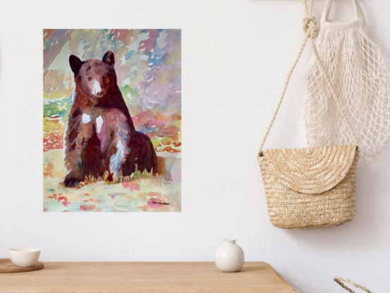 artwork featuring an American Black Bear sitting on the ground and looking at the camera

