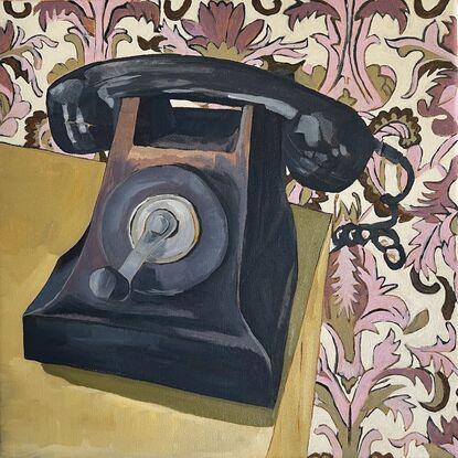 Vintage black windup telephone with blush pink and green leaf pattern wallpaper