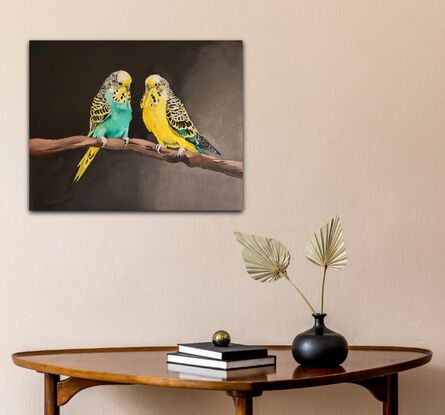 Two budgerigars sitting on a branch.